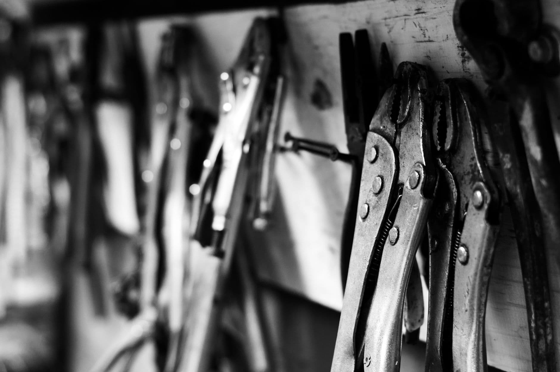 Plumbing hand tools laid out on a workbench